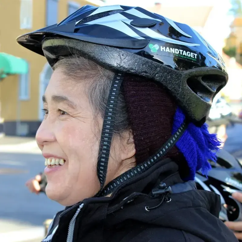 Leende medarbetare i cykelhjälm med Handtagets logga