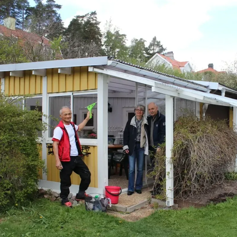 Medarbetare putsar fönster i ett uterum medan kunderna ser på