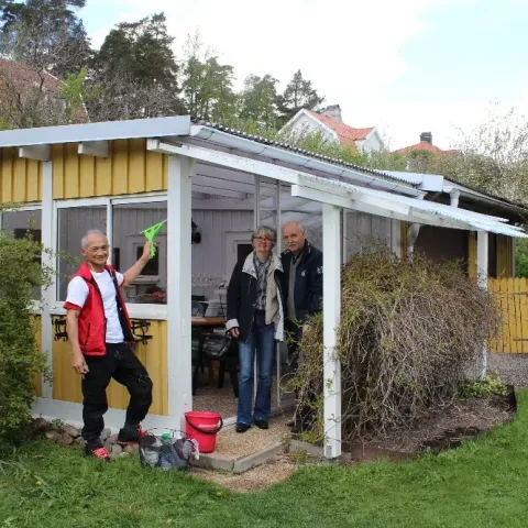 Medarbetare putsar rutor i ett lusthus medan kunderna ser på